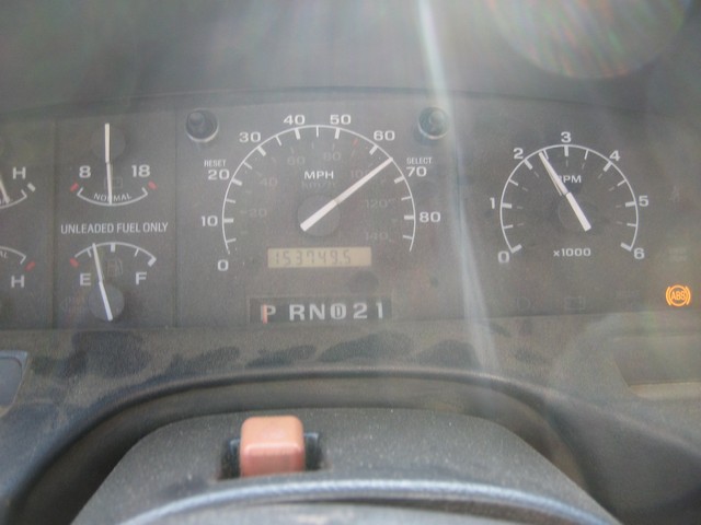 1995 Ford Bronco dashboard with speedometer, tachometer, fuel gauge, odometer at 153749.5 miles, and illuminated ABS light.