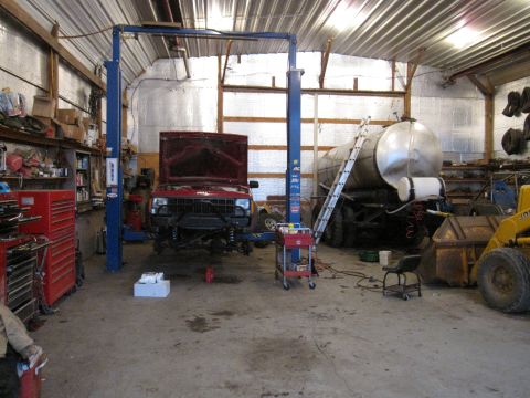 1992 Ford Bronco - Photograph of a red Jeep Cherokee raised on a lift in a workshop, not a document.