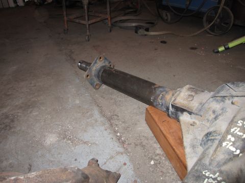 1992 Ford Bronco - Photograph of a driveshaft connected to a differential on a garage floor, not a document.