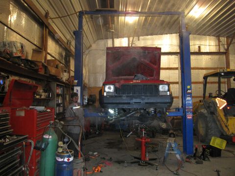 1992 Ford Bronco - Photograph of a Jeep raised on a lift during repair work, not a document.