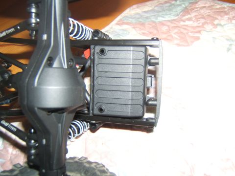 1988 Ford Bronco - A close-up view of the rear axle and suspension components of a remote-controlled vehicle. A black plastic battery box is mounted to the ch…
