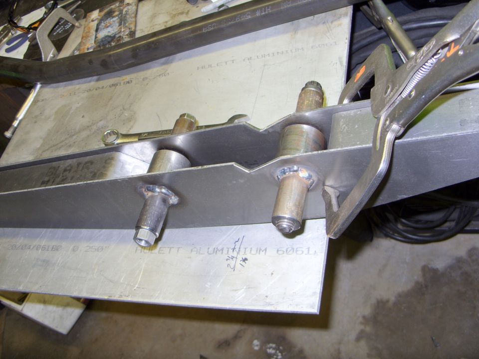 Welded aluminum fabrication with text "HULETT ALUMINIUM 6061" and a locking plier clamp.