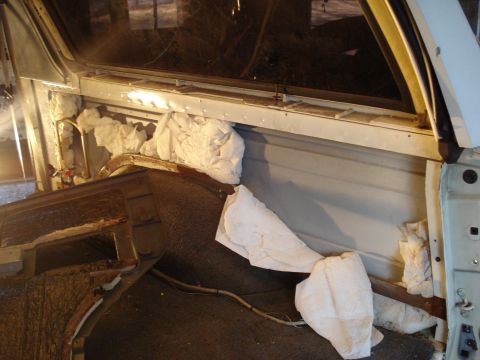 1991 Ford Bronco - The interior of a vehicle undergoing restoration, with white packing material stuffed around the dashboard and A-pillar area.