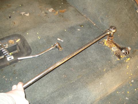 1991 Ford Bronco - A hand holds a metal rod that is part of a mechanism attached to the floor of a vehicle. A ratchet and a Torx bit are also visible on the c…