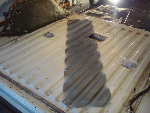 1991 Ford Bronco - The interior of a vehicle, likely a Ford Bronco, shows a stripped-down floor with a ribbed metal surface. A shadow is cast across the floor…