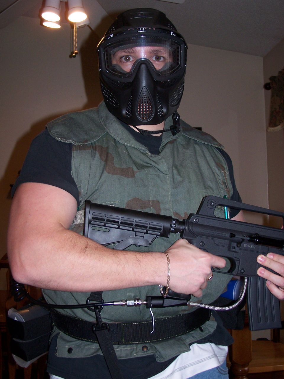 Person in paintball gear holding a paintball gun.