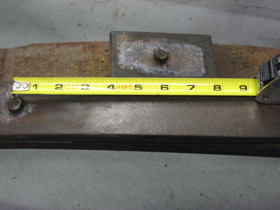 Yellow measuring tape on rusty leaf spring, measuring 8.5 inches.