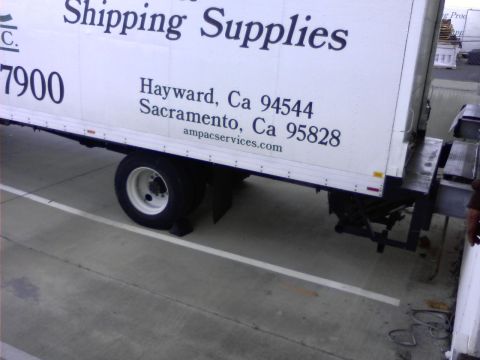 1989 Ford Bronco - The side of a white box truck is visible, featuring text that reads "Shipping Supplies" and addresses in Hayward and Sacramento, California…