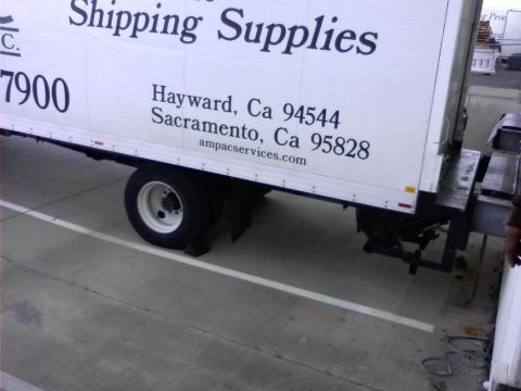 1989 Ford Bronco - The side of a white box truck is shown parked on a concrete surface. Text on the truck reads "Shipping Supplies" and lists addresses in Hay…