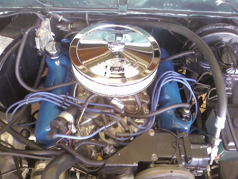 Ford V8 engine bay with blue valve covers and chrome air cleaner.