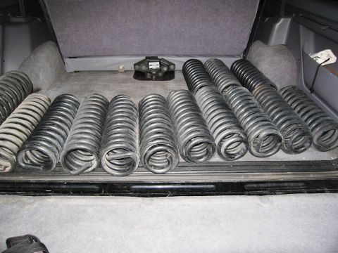 1986 Ford Bronco - A collection of black and silver coil springs are neatly arranged in the cargo area of an SUV. A trailer hitch is visible mounted to the re…