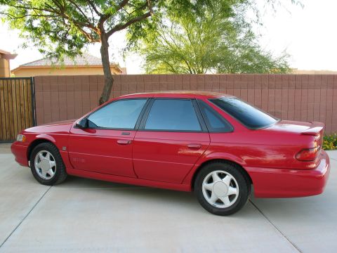 1995 Ford Taurus - Side view of a red 1995 Ford Taurus sedan.