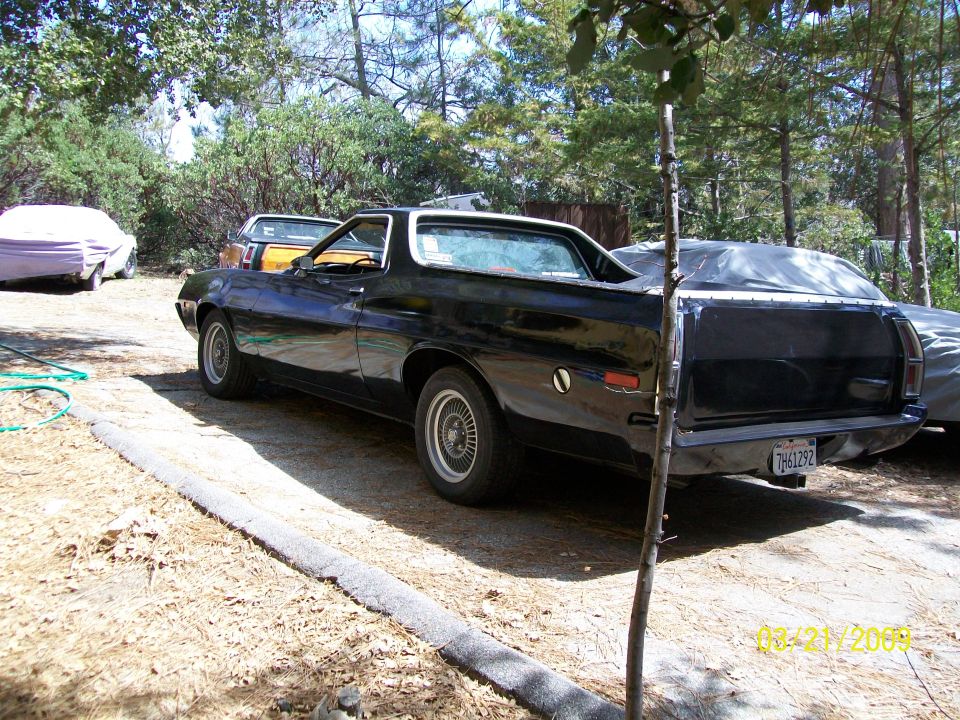 Black 1972 Ford Ranchero parked outdoors, rear three-quarter view.