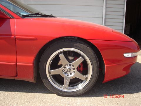 1993 Ford Probe - The front driver's side fender, door, and wheel of a red 1993 Ford Probe are shown. The vehicle has a custom five-spoke silver alloy wheel…