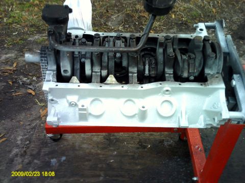 1992 Ford Bronco - A disassembled engine block, painted white, is mounted on a red engine stand. The crankshaft and connecting rods are visible inside the blo…