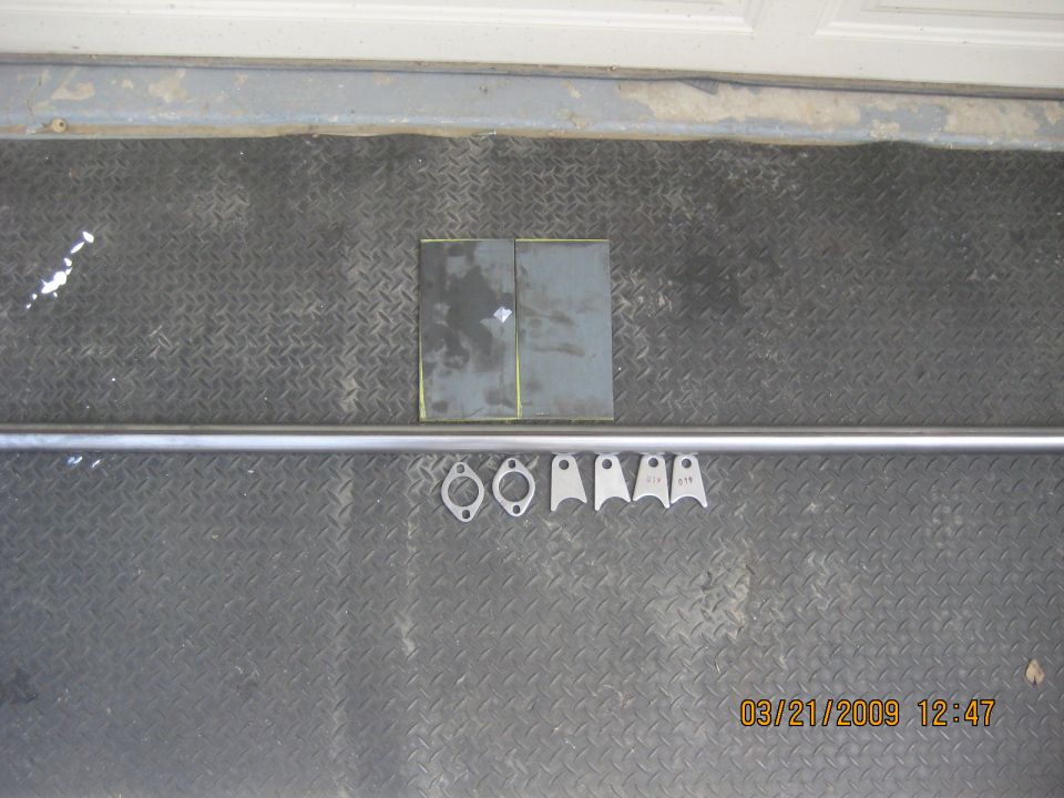 Metal bar, brackets, and plates on a diamond plate floor.