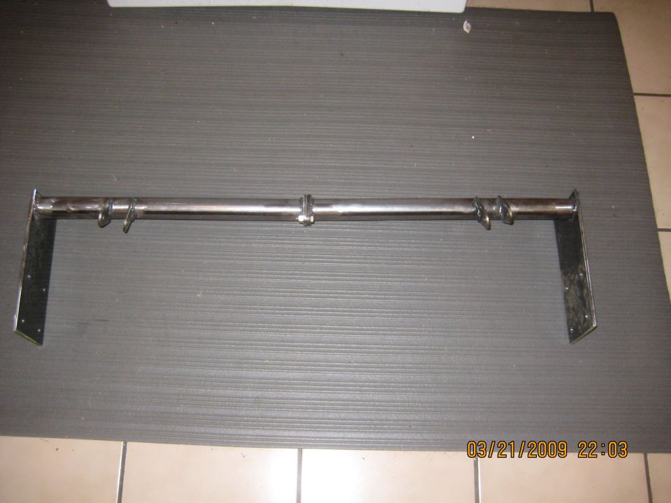 Custom metal bracket with hooks mounted on a bar, likely for a vehicle.
