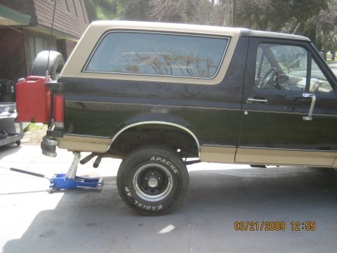 1909 Ford Bronco - This Ford Bronco, likely from the 1980s, is shown from the side with a red gas can and spare tire mounted on the rear.