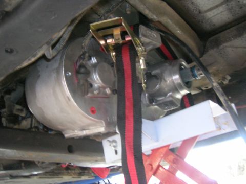 1996 Ford Bronco - Close-up view of a vehicle's transmission and driveshaft, secured with a ratchet strap.
