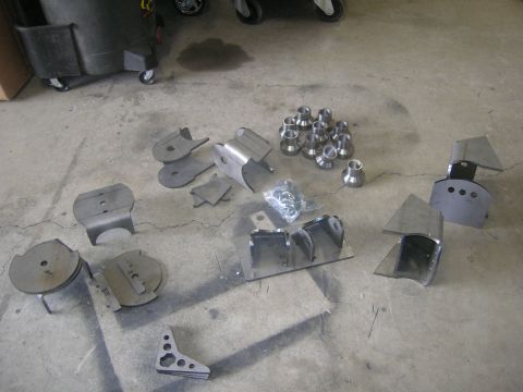 1996 Ford Bronco - Collection of unassembled suspension parts and fasteners on a workshop floor.
