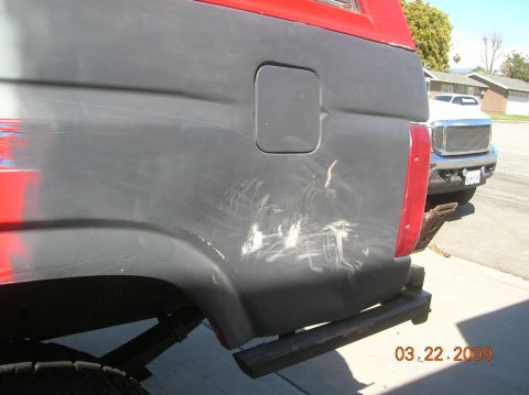 1985 Ford Bronco - The rear of a heavily scratched vehicle, possibly a Ford Bronco, is shown with a second vehicle in the background. The date 03.22.2009 is v…