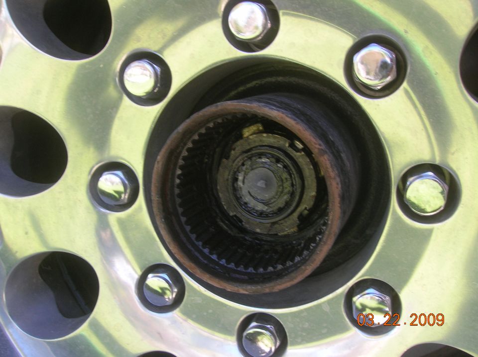 Close-up of a wheel hub assembly with lug nuts and splined internal mechanism