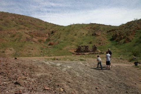 1991 Ford Bronco - A desert scene with rocky hills, ancient ruins, and a few people exploring the area.