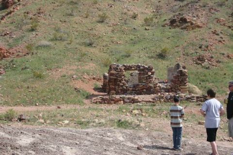 1991 Ford Bronco - People stand near old stone ruins in a barren, grassy environment.