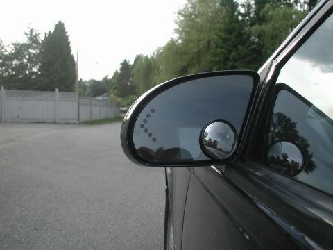 1990 Ford Thunderbird - Side mirror assembly on a car, a convex blind spot mirror and indicator lights.