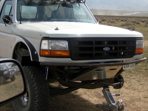 1996 Ford Bronco - Front three-quarter view of a white 1990s Ford Bronco/F-Series with black grille bearing the Ford oval, showing a custom tubular front bump…