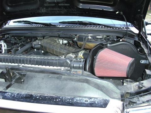 2005 Ford F-250 - The engine bay of a 2005 Ford F-250 features a prominent red K&N air filter and intake system.