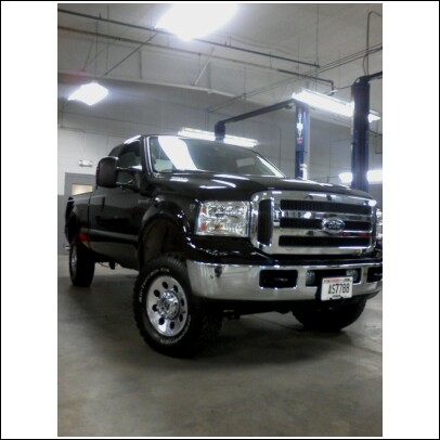 2005 Ford F-250 - This black 2005 Ford F-250 pickup truck is shown from a three-quarter front view in a garage.