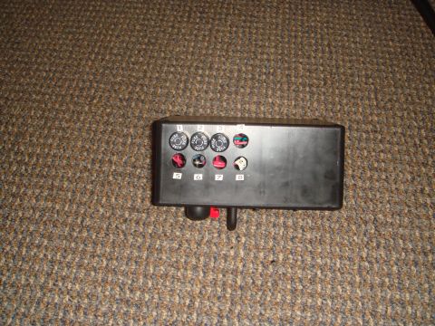 1992 Ford Bronco - A black fuse box with eight numbered fuse slots is shown on a brown carpeted surface. Four of the fuse slots are visible with the labels "F…