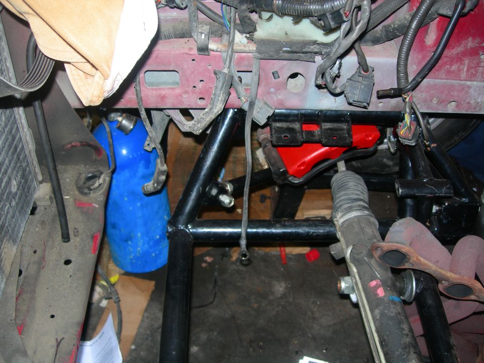 Close-up of vehicle engine bay with roll cage and nitrous bottle