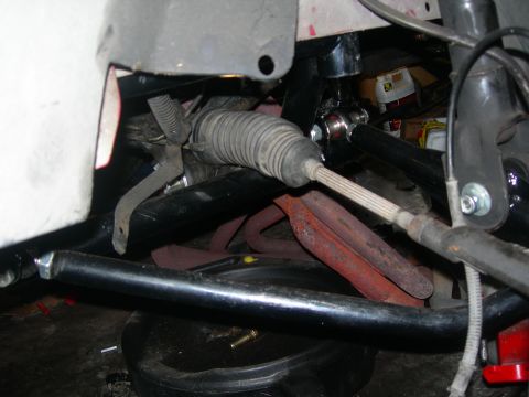 1984 Ford Bronco - A close-up view of a vehicle's steering and suspension components, including the steering rack, tie rod, and exhaust manifold. The scene ap…