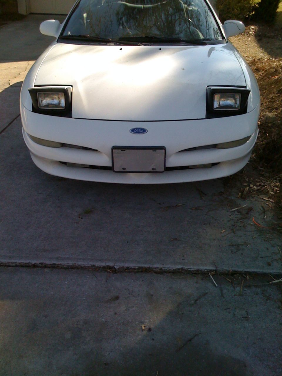 Front view of a white Ford Probe with pop-up headlights raised