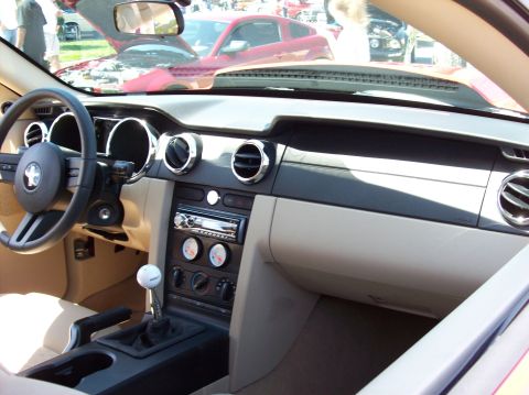 2007 Ford Mustang - The interior of a Ford Mustang is shown, focusing on the dashboard and center console. Visible features include the steering wheel, gear sh…