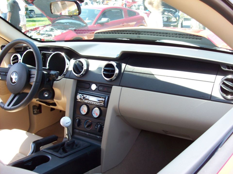Interior of a Ford Mustang showing dashboard, steering wheel, and gear shifter.