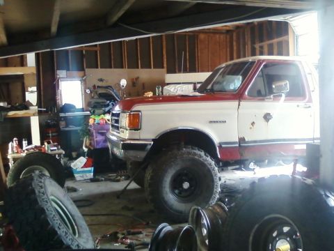 1991 Ford Bronco - This 1991 Ford Bronco is parked inside a garage, surrounded by spare tires and tools.