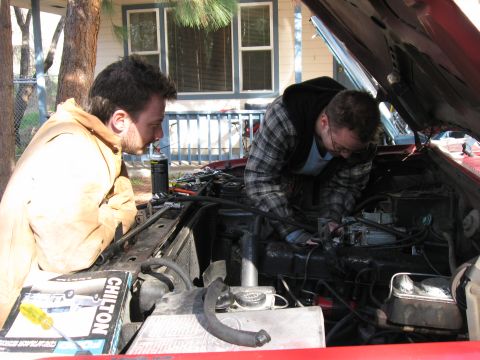 1981 Ford Bronco - Me working away while my brother supervises. This picture is interesting because it shows how the intake is designed to keep the carb flat…