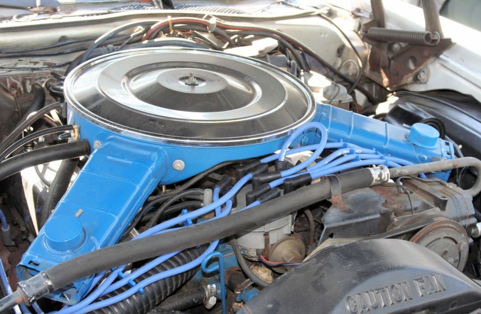Blue air cleaner assembly and spark plug wires in engine bay