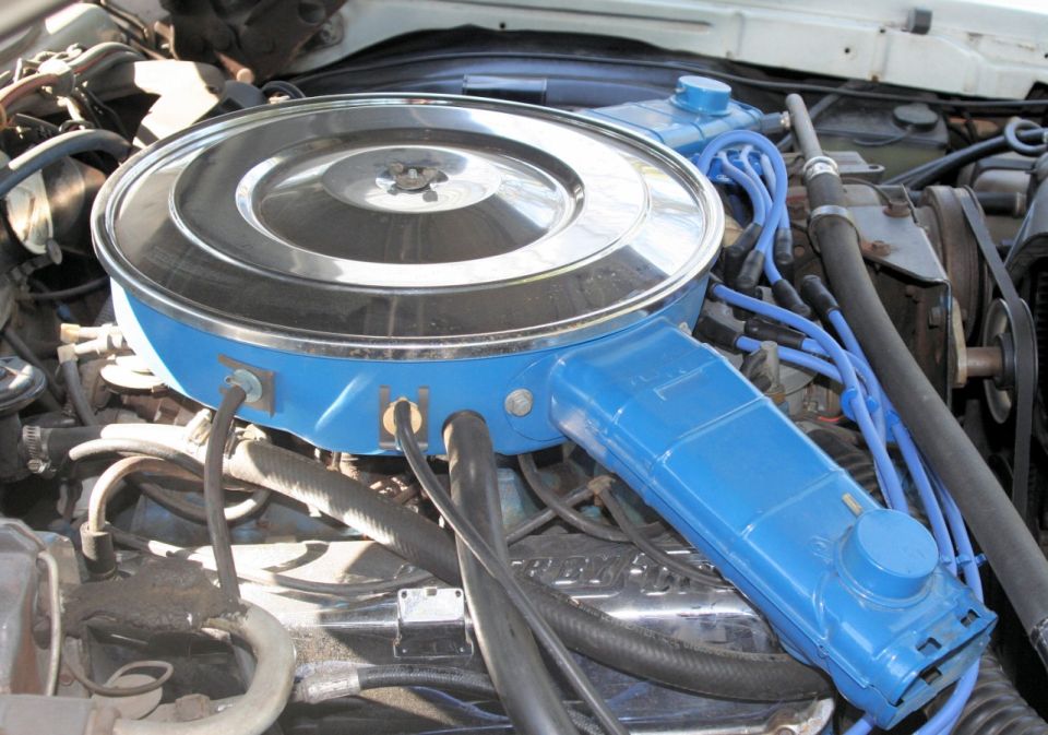 Engine bay detail showing a blue air cleaner assembly and spark plug wires