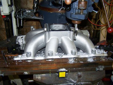 1996 Ford Bronco - An intake manifold is being worked on by a milling machine in a workshop.