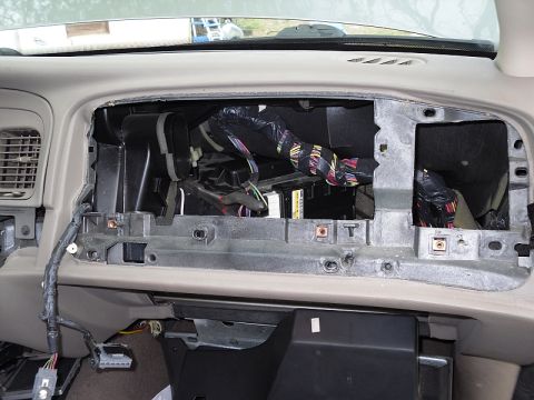 2004 Mercury Marquis - The interior of a car's dashboard is exposed, revealing the internal components and wiring harness.