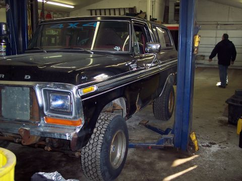 1979 Ford Bronco - Black 1978 Ford Bronco is raised on a lift inside a workshop.