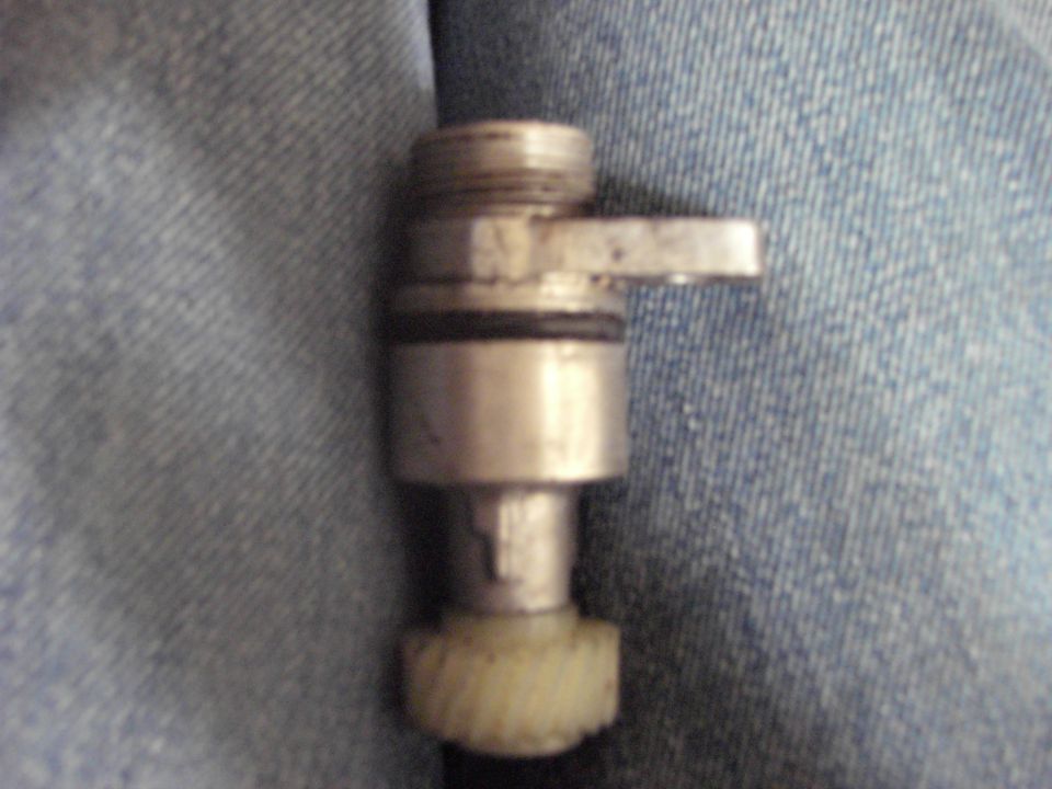 Vehicle speed sensor with gear against blue denim.