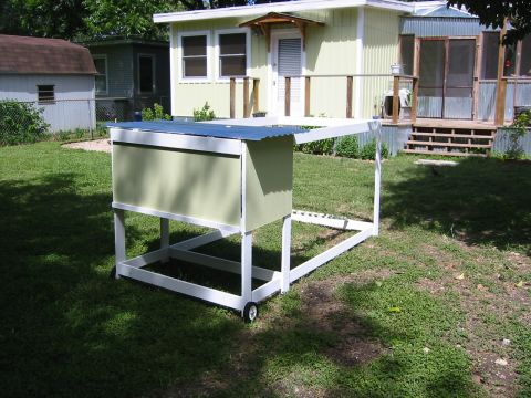 1996 Ford Bronco - A light green and white chicken coop with a corrugated metal roof sits on a grassy lawn in front of a light yellow house.