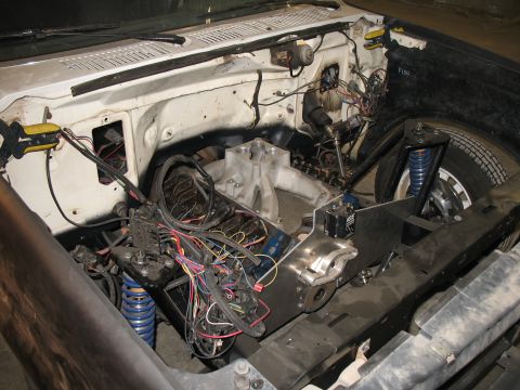 1994 Ford F-150 - Overhead view into the engine bay of a stripped white pickup during a rewire, showing a V8 with a bare aluminum intake manifold, no carbure…