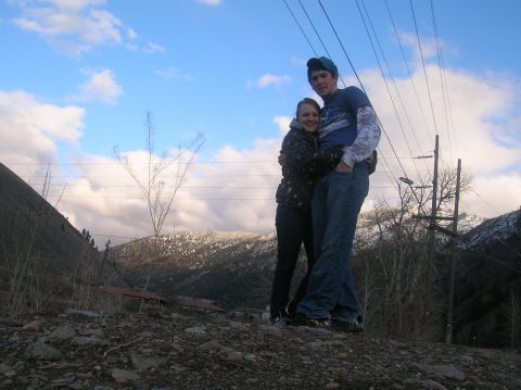 1996 Ford Bronco - A young couple embraces while standing outdoors with a scenic mountain landscape in the background.
