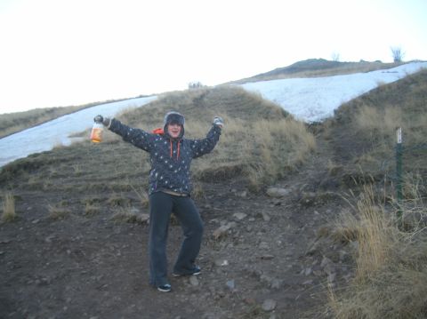 1996 Ford Bronco - A person in a hooded jacket and hat holds up a bottle while standing on a dirt path with snow-covered hills in the background.